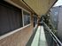 Charming apartment balcony with elegant iron railing, offering a serene view of lush greenery and adjacent buildings.