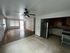 Bright open-plan apartment with a spacious living area, hardwood floors, modern ceiling fan, and a cozy kitchen with stainless steel appliances.