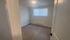 Bright, spacious room with modern wood flooring and a large window inviting natural light.
