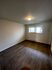 Bright and inviting empty room with sleek wood flooring, modern lighting, and ample natural light from the window.