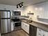 Modern kitchen with sleek stainless steel appliances, elegant white cabinetry, and stylish under-cabinet lighting.