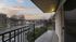 Scenic balcony view overlooking a peaceful street and lush greenery, perfect for relaxation.