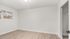 Bright, spacious bedroom with sleek hardwood floors and a large window offering natural light, complete with a convenient built-in closet.