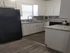 Modern kitchen with sleek granite countertops, elegant white cabinetry, and stainless steel appliances, offering a contemporary and inviting space.