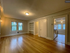 Inviting apartment with spacious hardwood floored living area, built-in shelving, and cozy kitchen access.