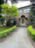 Charming brick apartment complex with lush greenery and inviting entrance path.