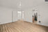 Sleek apartment interior with elegant wood flooring, open closet space, and modern stainless steel kitchen appliances.
