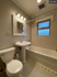 Charming bathroom with elegant fixtures, classic tile flooring, and natural light from a frosted window.