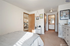 Bright bedroom with cozy carpeted flooring, stylish decor, and convenient access to an adjoining bathroom and kitchen area.
