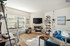 Inviting living room with modern decor, cozy fireplace, and abundant natural light from large windows.