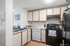 Charming kitchen with modern appliances and ample cabinet space, featuring sleek wooden accents and a cozy atmosphere.