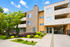 Charming apartment complex surrounded by lush greenery and modern architecture, offering a welcoming atmosphere.