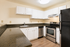 Modern kitchen with sleek black appliances, elegant dark countertops, and bright white cabinetry.