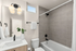 Bright, modern bathroom with sleek fixtures, elegant grey tiles, and natural light.