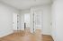 Bright hallway with elegant wood flooring, leading to modern bathroom and inviting rooms.