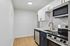 Chic modern kitchen with sleek stainless steel appliances, elegant white cabinetry, and stylish gold fixtures.