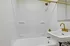 Elegant bathroom featuring a white bathtub with gold fixtures and a modern sink, creating a luxurious feel.