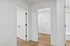 Bright modern hallway with sleek wooden flooring and crisp white doors, offering a glimpse into a stylish and spacious apartment interior.