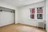 Bright and inviting room with large windows, showcasing modern hardwood floors and a spacious open closet.