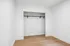 Spacious empty closet with sleek design, featuring a modern wooden floor and a sturdy hanging rod.
