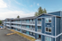 Inviting blue apartment complex with modern design, featuring spacious balconies and convenient parking.