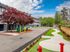 Charming apartment exterior with vibrant landscaping, featuring a winding path, colorful foliage, and modern architecture under a bright blue sky.