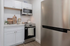 Modern compact kitchen featuring sleek stainless steel appliances, chic white cabinetry, and elegant decor elements.
