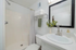 Modern bathroom featuring a sleek vanity, large mirror, and fresh decor with abundant natural light.