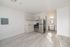 Modern apartment kitchen with sleek stainless steel appliances, elegant light wood cabinetry, and pristine light wood flooring.