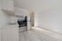 Bright and modern kitchen with sleek stainless steel appliances, light wood cabinetry, and spacious open layout.