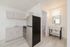 Modern apartment with sleek kitchen, featuring stainless steel appliances and contemporary cabinetry, adjacent to a stylish bathroom with elegant lighting.