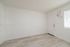 Bright, modern room with sleek wood flooring and ample natural light through a large window.