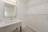 Bright and spacious laundry room featuring sleek countertops, a large mirror, and built-in shelving perfect for storage.