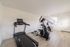 Bright and modern home gym featuring a treadmill and elliptical trainer on sleek wooden floors, perfect for a convenient workout.