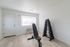 Bright home gym room featuring a sleek weight bench and organized dumbbell rack on modern flooring.