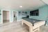 Inviting game room with a stylish pool table, vibrant teal walls, and chic artwork displaying modern elegance.