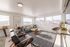 Bright and modern living room featuring large windows, stylish furniture, and elegant decor with a natural wood coffee table.