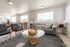 Bright and inviting living room featuring modern furnishings, including a stylish glass coffee table and a cozy couch accented with decorative pillows, offering a perfect blend of comfort and elegance.