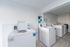 Bright and modern laundry room featuring state-of-the-art washing machines, perfect for convenient and efficient living.