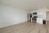 Bright, modern kitchen with sleek stainless steel appliances and elegant white cabinetry, against a backdrop of warm wood flooring.