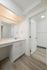 Bright and modern bathroom with a sleek vanity, large mirror, and elegant wood flooring.