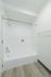 Bright and modern bathroom with sleek white tiles and a clean, elegant shower-tub combination.