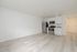 Modern open-concept kitchen with sleek stainless steel appliances, chic white cabinetry, and elegant wood flooring.