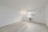 Bright and airy room with elegant light wood flooring and a natural light-filled window, offering a serene and refreshing ambiance.
