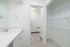 Bright modern bathroom with sleek vanity, spacious mirror, and ample shelving for storage.