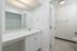Bright and modern bathroom featuring a sleek white vanity, large mirror, and elegant fixtures.