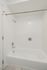 Modern bathroom with a pristine white bathtub, sleek chrome fixtures, and elegant tiled walls, offering a relaxing space.