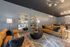 Chic living room with stylish leather sofas, elegant mirrors, and modern chandeliers creating a cozy and inviting atmosphere.