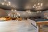Stylish lounge with modern decor, featuring plush leather sofas, a vibrant area rug, elegant chandeliers, and a pool table for ultimate relaxation.
