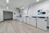 Contemporary apartment laundry room with modern washers, sleek flooring, and bright lighting.